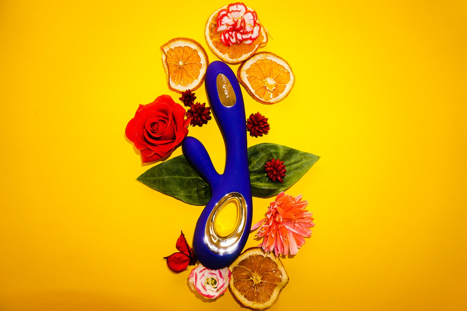 A Vibrator with Flowers and Orange Slices for Decoration Lying Around It