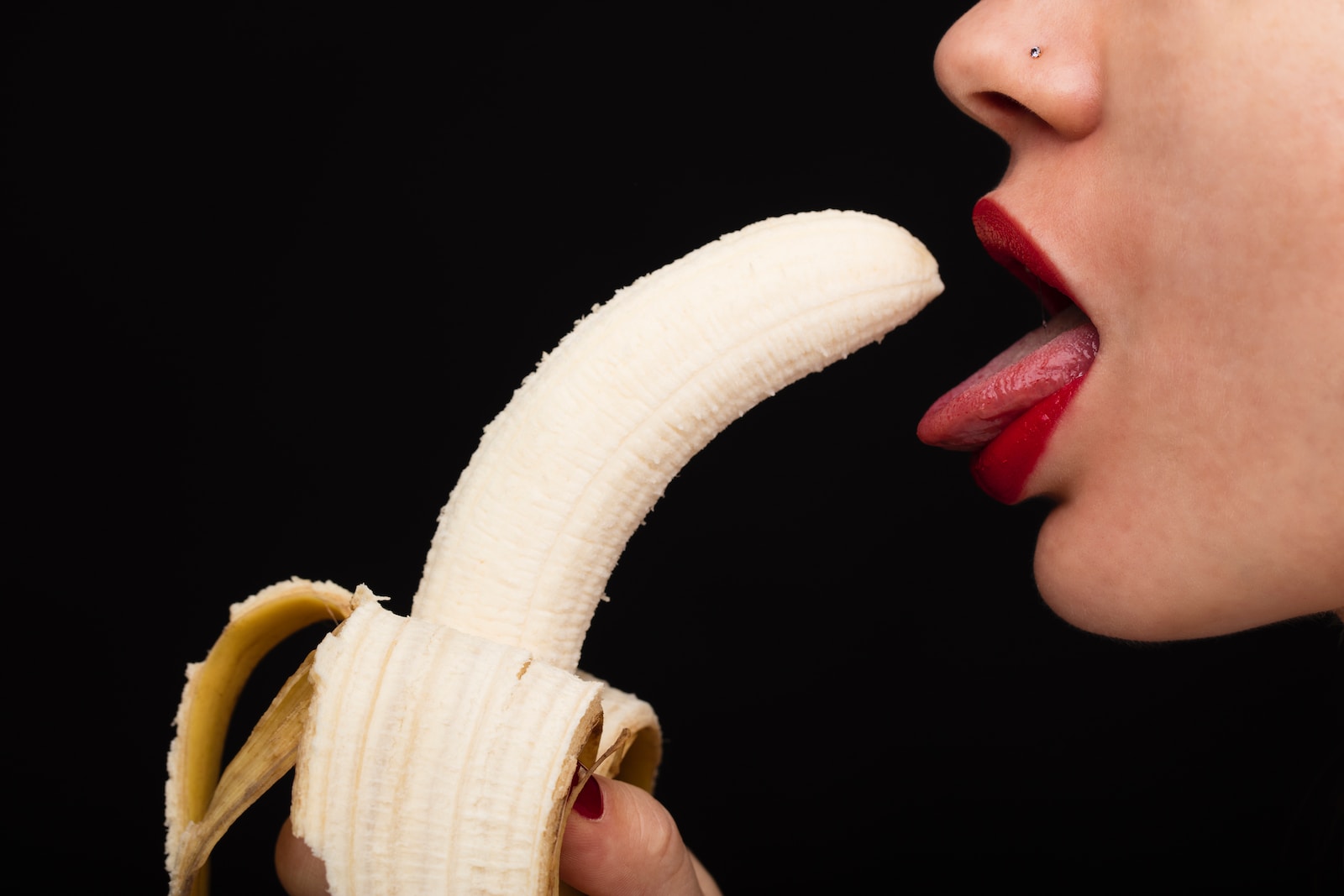 person holding banana with tongue out